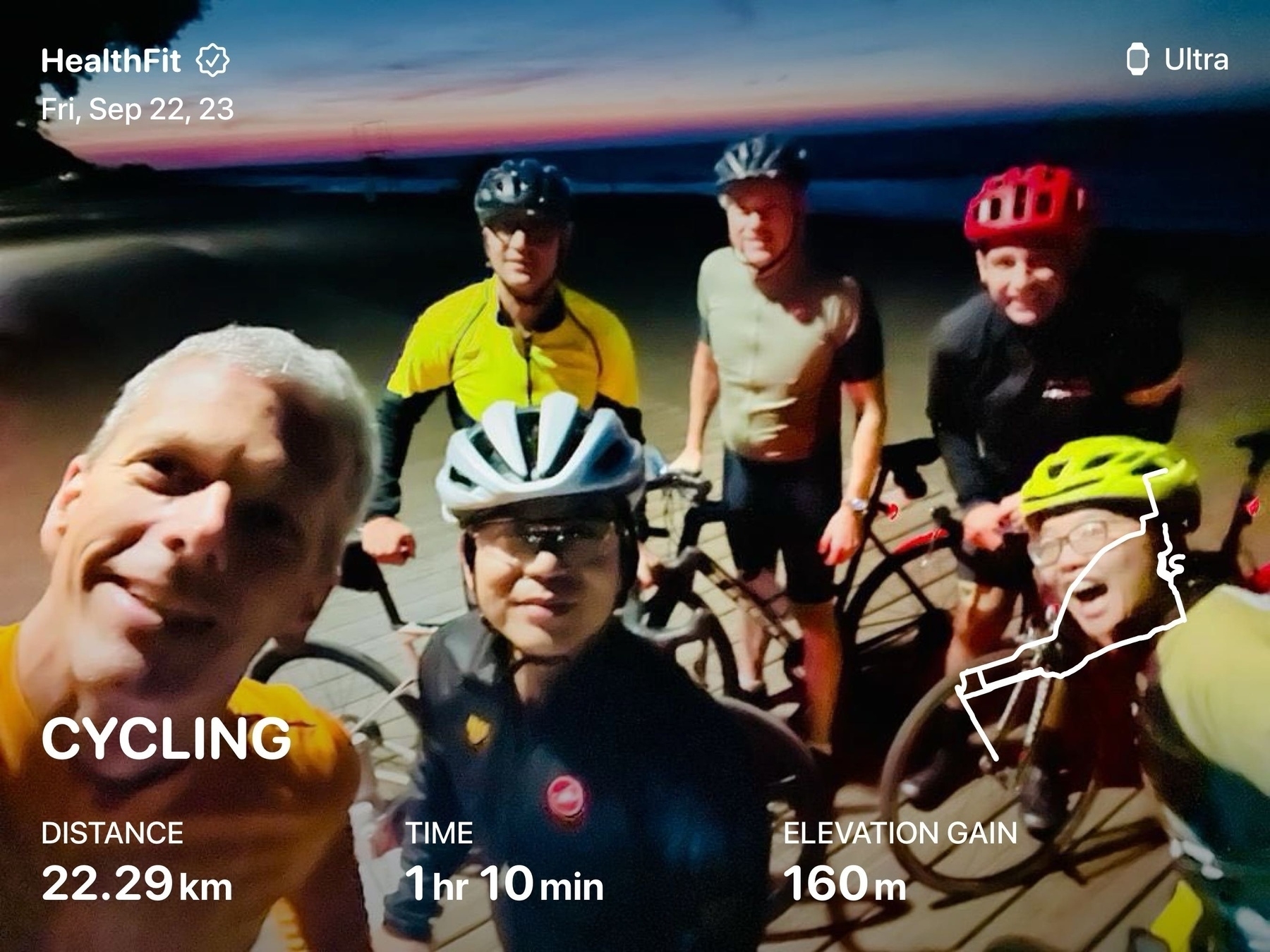 Crew of cyclist near a lake with the sunrise behind. Ride stats are overlaid: 22.39km 1hr10min
