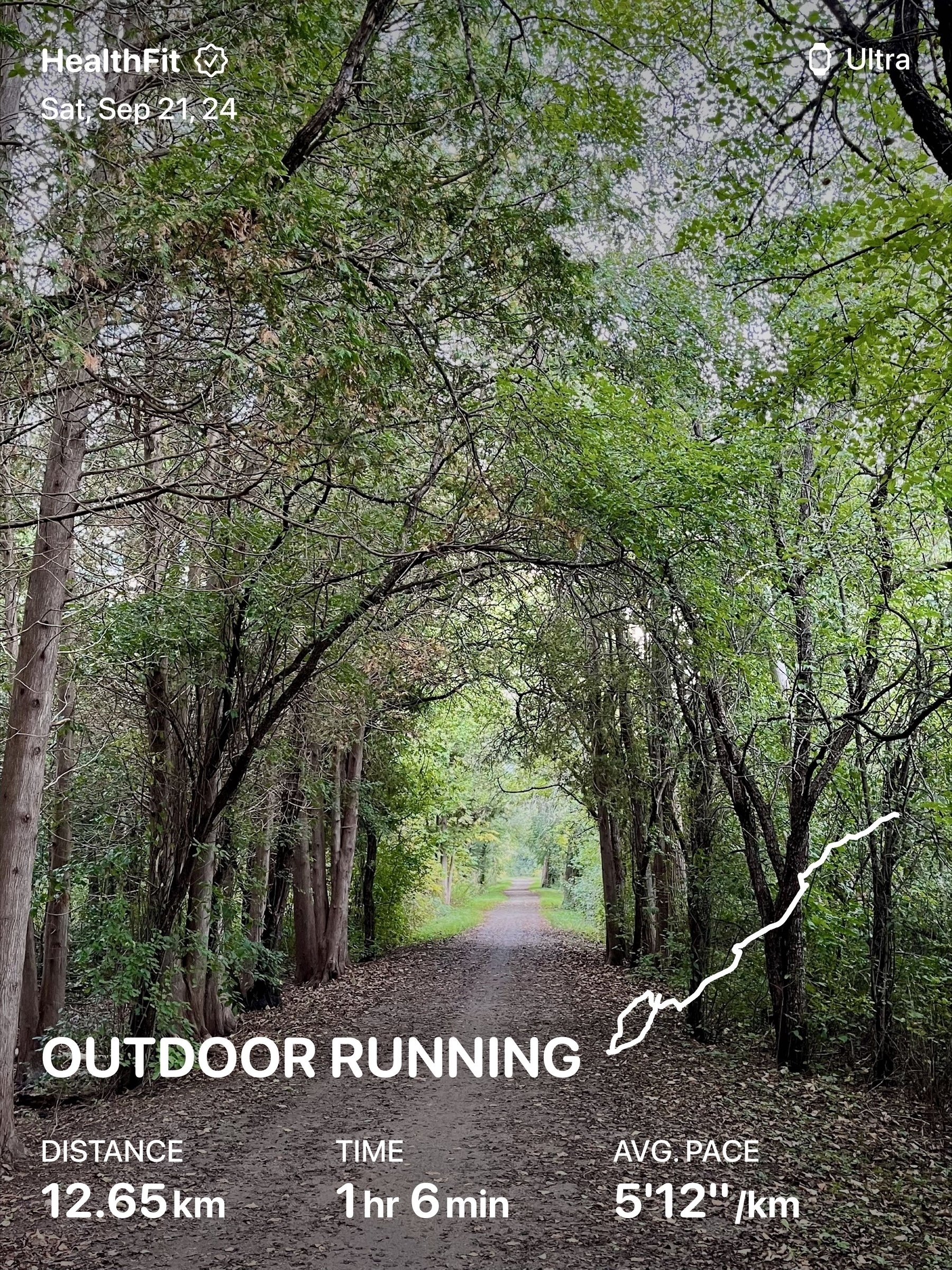 A scenic forest path is framed by arching trees with text overlaying details of an outdoor run, showing distance, time, and average pace.